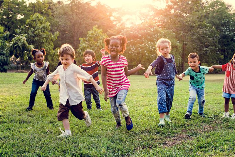 Diverse group of kids playing on the grass